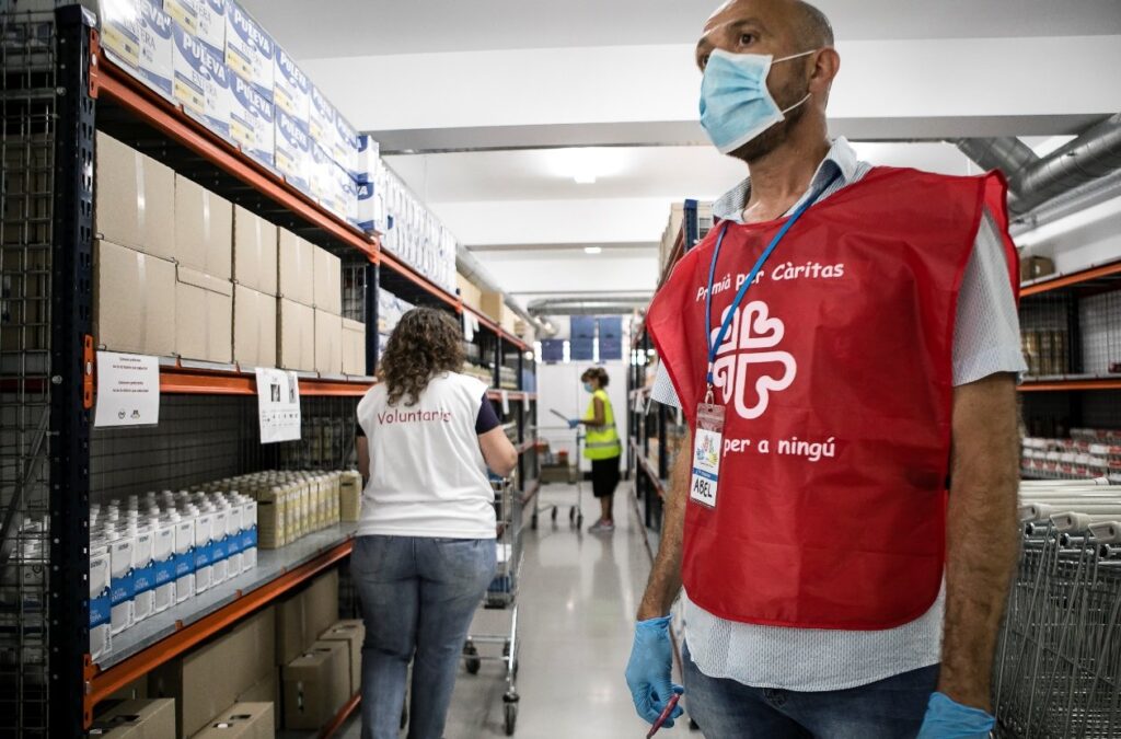 Trabajadores de Cáritas en un local de reparto de alimentos