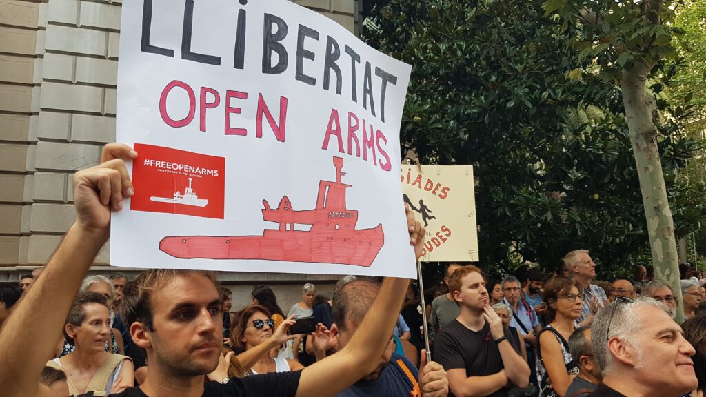 Un manifestante sostiene una pancarta de apoyo a Open Arms
