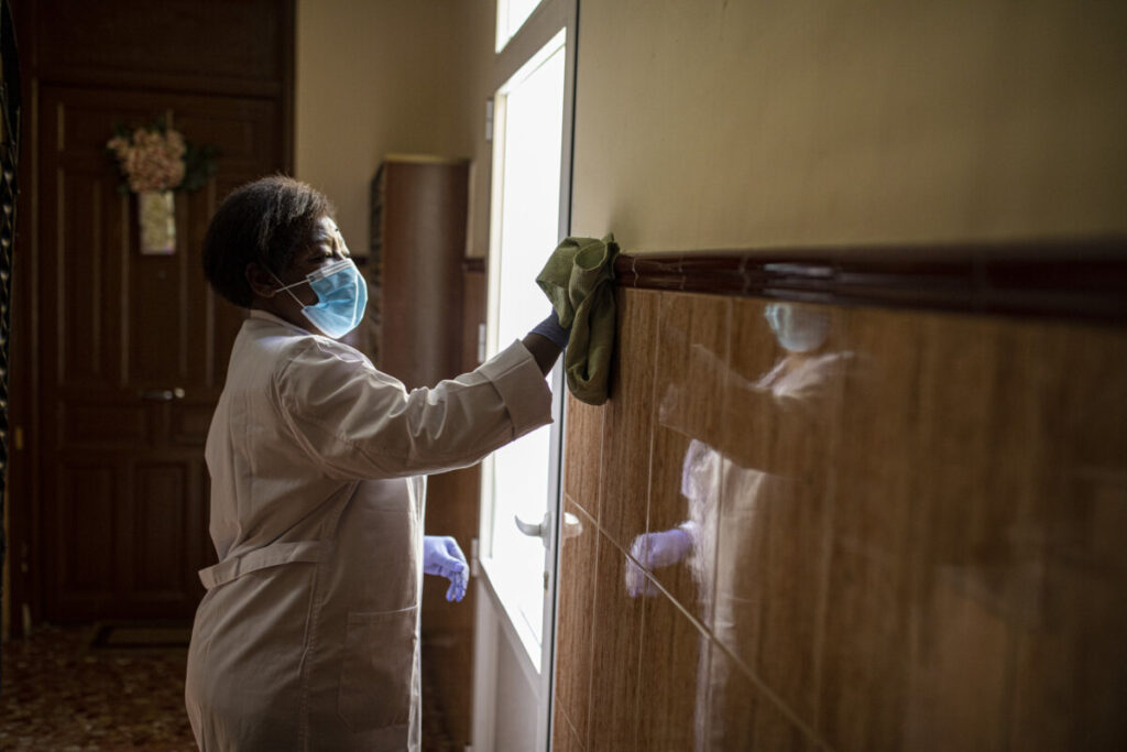 Una treballadora, netejant una paret