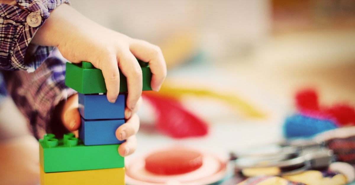 Un nen construeix una torre amb blocs de joguina (Esi Grünhagen, Pixabay)