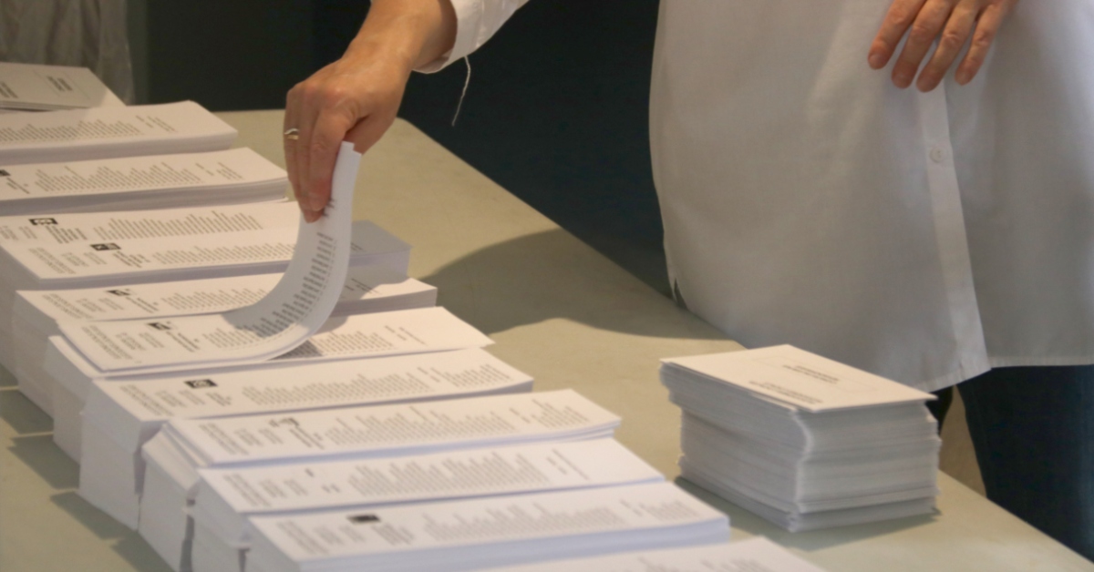 Una persona coge una de las papeletas electorales en un colegio electoral de Lleida (Ignasi Gómez, ACN)