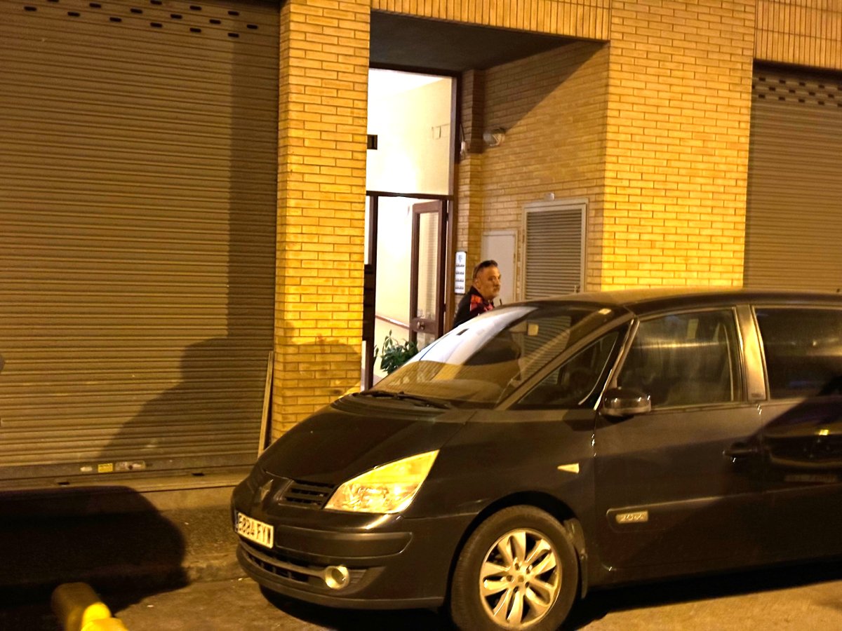 Un agent dels Mossos d'Esquadra custodia la porta d'un bloc de pisos en un dels quals ha aparegut el cadàver d'una dona