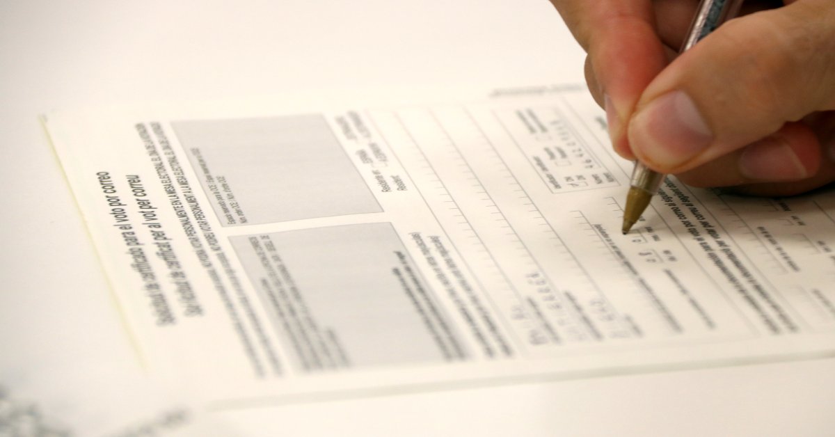 Un votant omple la sol·licitud de vot per correu a l'oficina de Correus de Gran de Gràcia de Barcelona (Guifré Jordan, ACN)