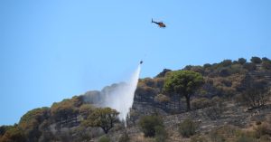 Un helicòpter descarregant aigüa en un dels focus de l'incendi de Portbou (Gerard Vilà, ACN)