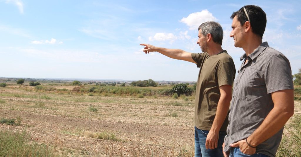 Gerard Batalla i Gerard Daniel, membres de la plataforma Pobles Vius, observen el terreny on està projectada la macrocentral de biogàs més gran de Catalunya a la Sentiu de Sió, Noguera (Alba Mor)
