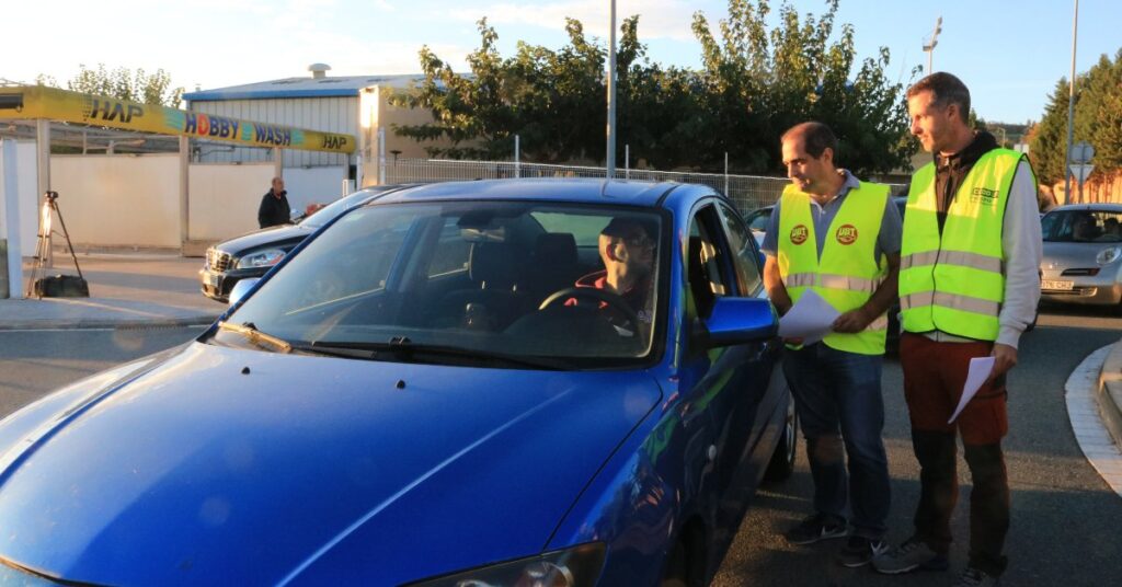 Dos membres de la representació sindical d'ANAV informen a un dels treballadors a la porta de la planta d'Ascó sobre l'acció d'aquest dissabte (Ariadna Escoda, ACN)