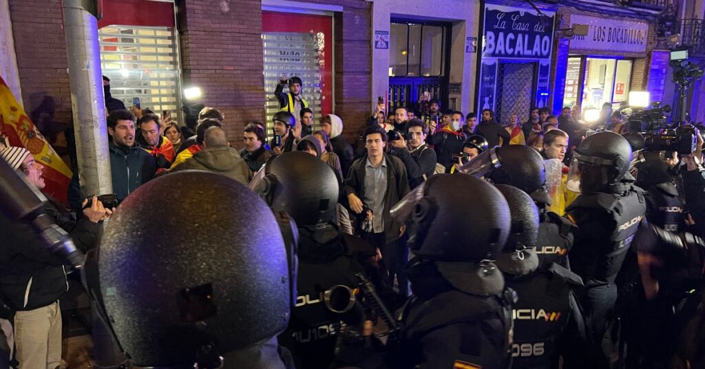 La policia rodeja un grup de manifestants després de les càrregues policials davant la seu del PSOE a Madrid (Arnau Martínez, ACN)