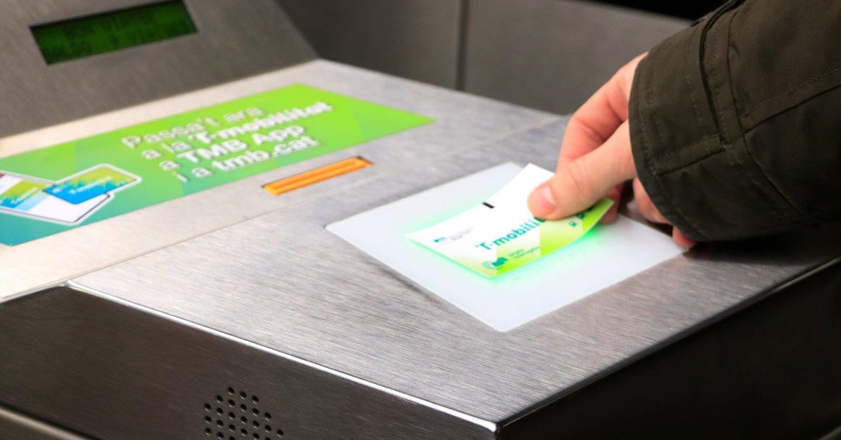 Un usuario valida la tarjeta de cartón recargable de la T-Mobilitat, que acaba de comprar en la estación de Sants de Barcelona (Laura Fíguls, ACN)