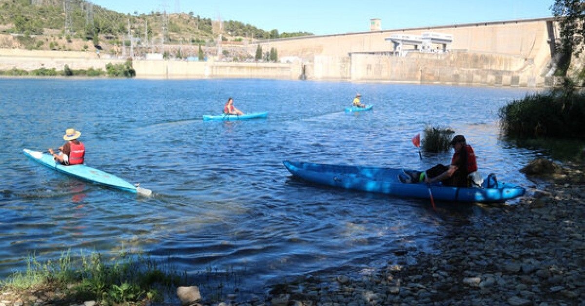 Participants a la Marxa dels Sediments entrant al riu Ebre amb els caiacs per baixar fins a Flix des del pantà de Riba-roja d'Ebre (Anna Ferràs, ACN)