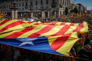 Una gran estelada cubre a algunos manifestantes en la movilización independentista en Barcelona con motivo de la Diada del 2024 (ACN)