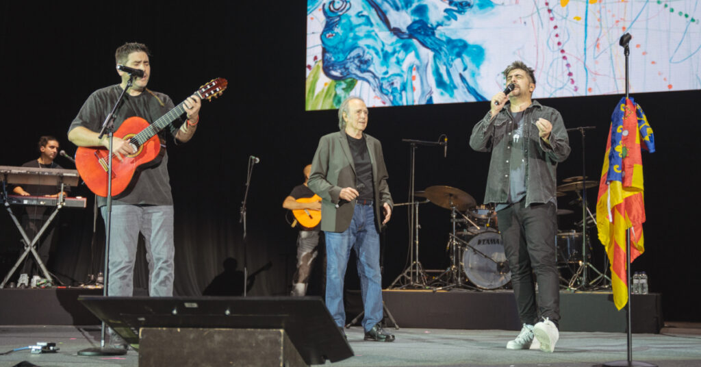 Estopa y Serrat en el escenario al final del concierto 'Barcelona con Valencia' en el Palau Sant Jordi (Marc Font, ACN)