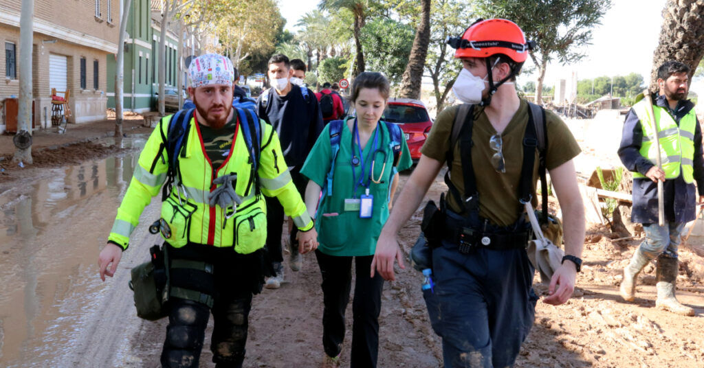 Una doctora y un enfermero voluntarios caminando por la zona devastada de Paiporta (Gemma Sánchez y Mar Rovira, ACN)