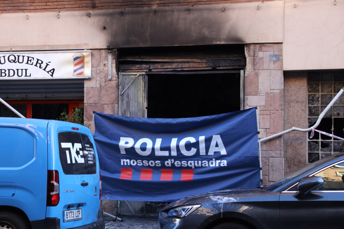 Una lona de los Mossos cubre la entrada a la planta baja incendiada en la calle Mestre Carbó de l'Hospitalet
