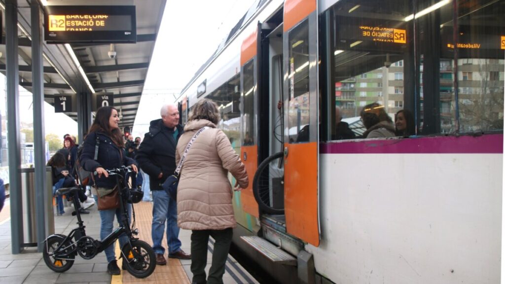 Diversos passatgers pujant en un tren a l'estació de Bellvitge-Gornal que va direcció Barcelona (Albert Hernàndez, ACN)