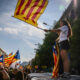 Una jove sosté una estelada durant la mobilització independentista de la Diada del 2024 (ACN)