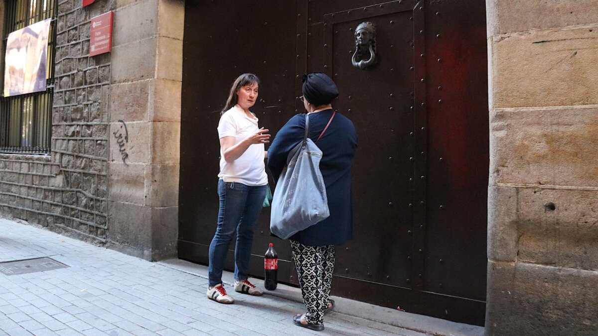 Dues de les participants de l'assemblea esperant a la porta abans de l'inici de la reunió (Norma Vidal, ACN)