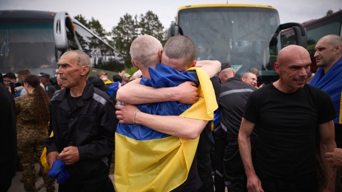 Presoners ucraïnesos intercanviats arran de l'acord entre Rússia i Ucraïna s'abracen al ser alliberats, portant a sobre una bandera ucraïnesa (Govern d'Ucraïna)