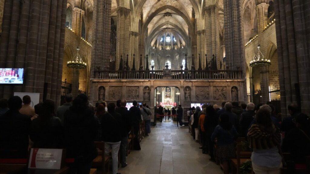 Varias personas en el interior de la catedral de Barcelona siguiendo la misa (Eli Don, ACN)