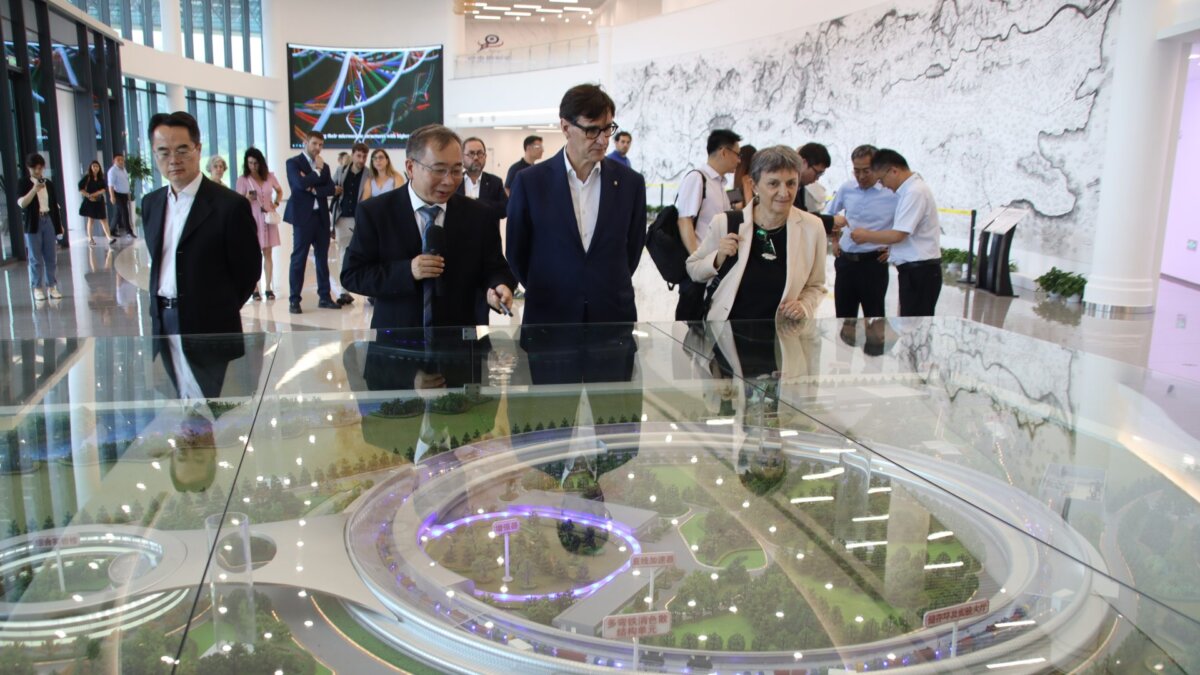 El presidente de la Generalitat, Salvador Illa, y la directora del Sincrotrón ALBA, Caterina Biscari, observando una maqueta del acelerador de partículas de Pekín (Mariona Puig y Albert Segura, ACN)