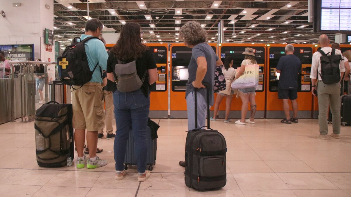 Personas esperando para utilizar una máquina de venta de billetes en la estación de Sants (Albert Hernàndez, ACN)