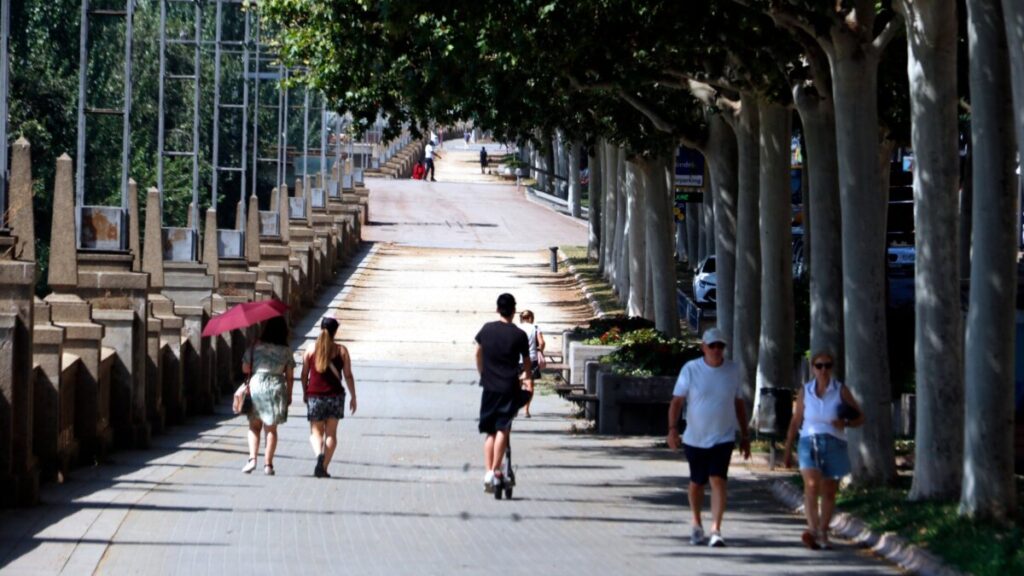Peatones caminando por la sombra en Lleida bajo un intenso calor (Roger Segura, ACN)