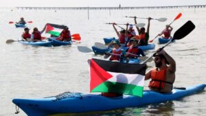 Participantes en el acto de apoyo a la Flotilla del Movimiento Global por Gaza, navegando en kayak por la bahía de los Alfacs (Jordi Marsal, ACN)