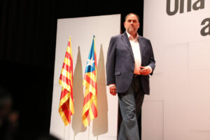 Junqueras en un evento con banderas catalanas de fondo