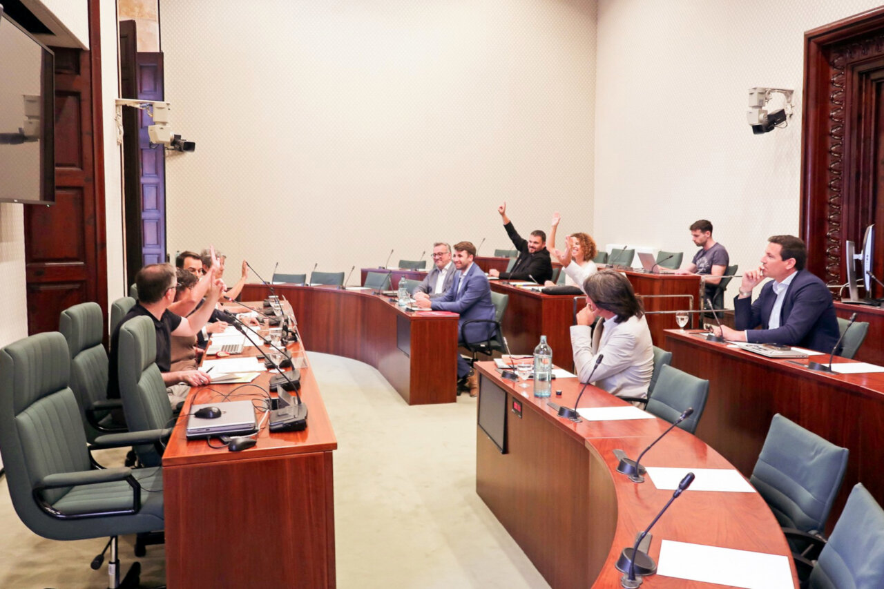 Personas levantando la mano durante una votación en una comisión