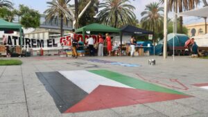 Una bandera de Palestina pintada en el punto de reparto de comida del campamento de Barcelona (Albert Segura, ACN)