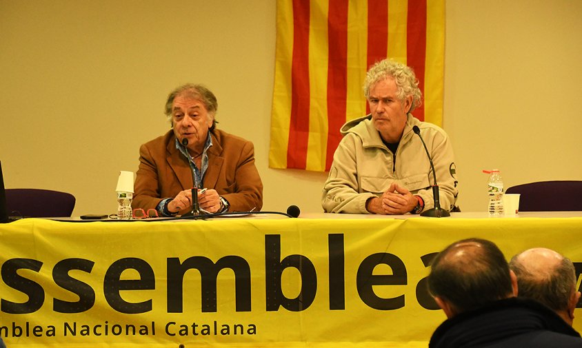 Josep Fajula parlant en una conferència a Cambrils amb una bandera catalana de fons.