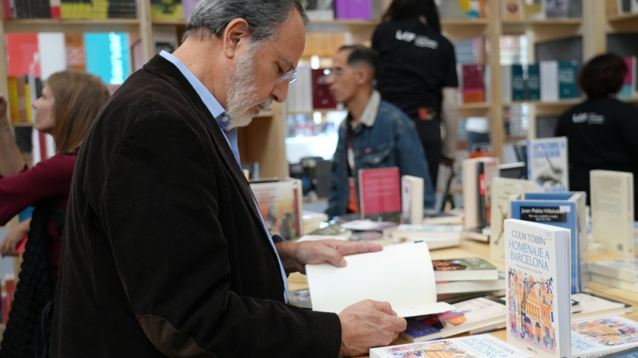 Un hombre observando los libros en el pabellón de Barcelona de la Feria Internacional del Libro de Guadalajara, México (Nico Tomás, ACN)