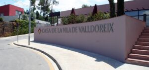 Entrada de la Casa de la Vila de Valldoreix amb vegetació al voltant.