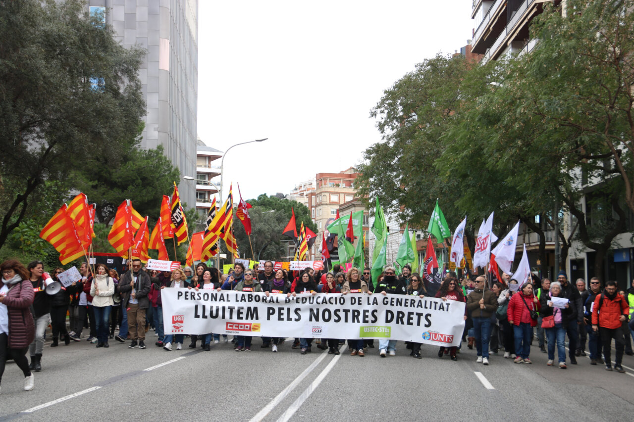 Manifestació del personal laboral d'educació a Barcelona amb pancartes i banderes