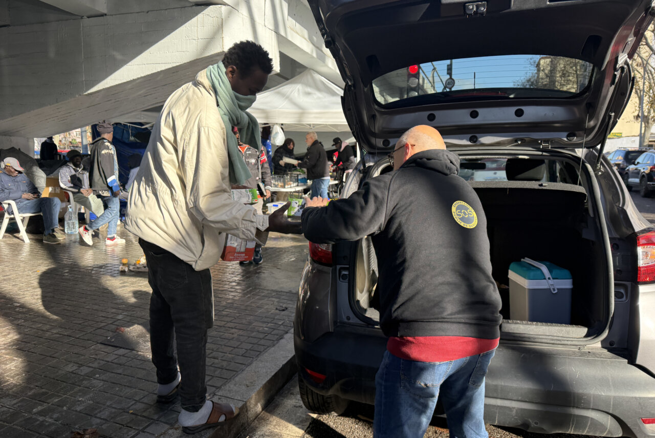 Voluntarios llevan comida al campamento que hay bajo el puente de la C-31 en Badalona (Mar Martí, ACN)