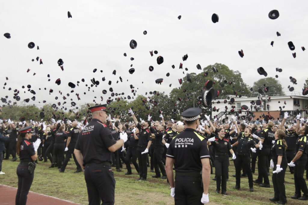 Celebració de graduació amb agents de policia llençant barrets