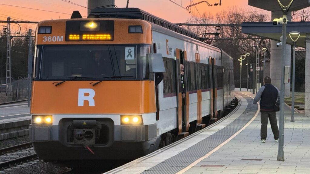 Un usuari de Rodalies parla amb un treballador d'un tren a l'andana de Maçanet (Gerard Vilà, ACN)