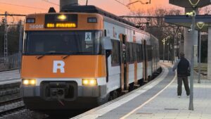 Un usuari de Rodalies parla amb un treballador d'un tren a l'andana de Maçanet (Gerard Vilà, ACN)