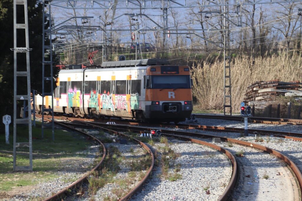 Tren de Rodalies amb grafits a les vies ferroviàries