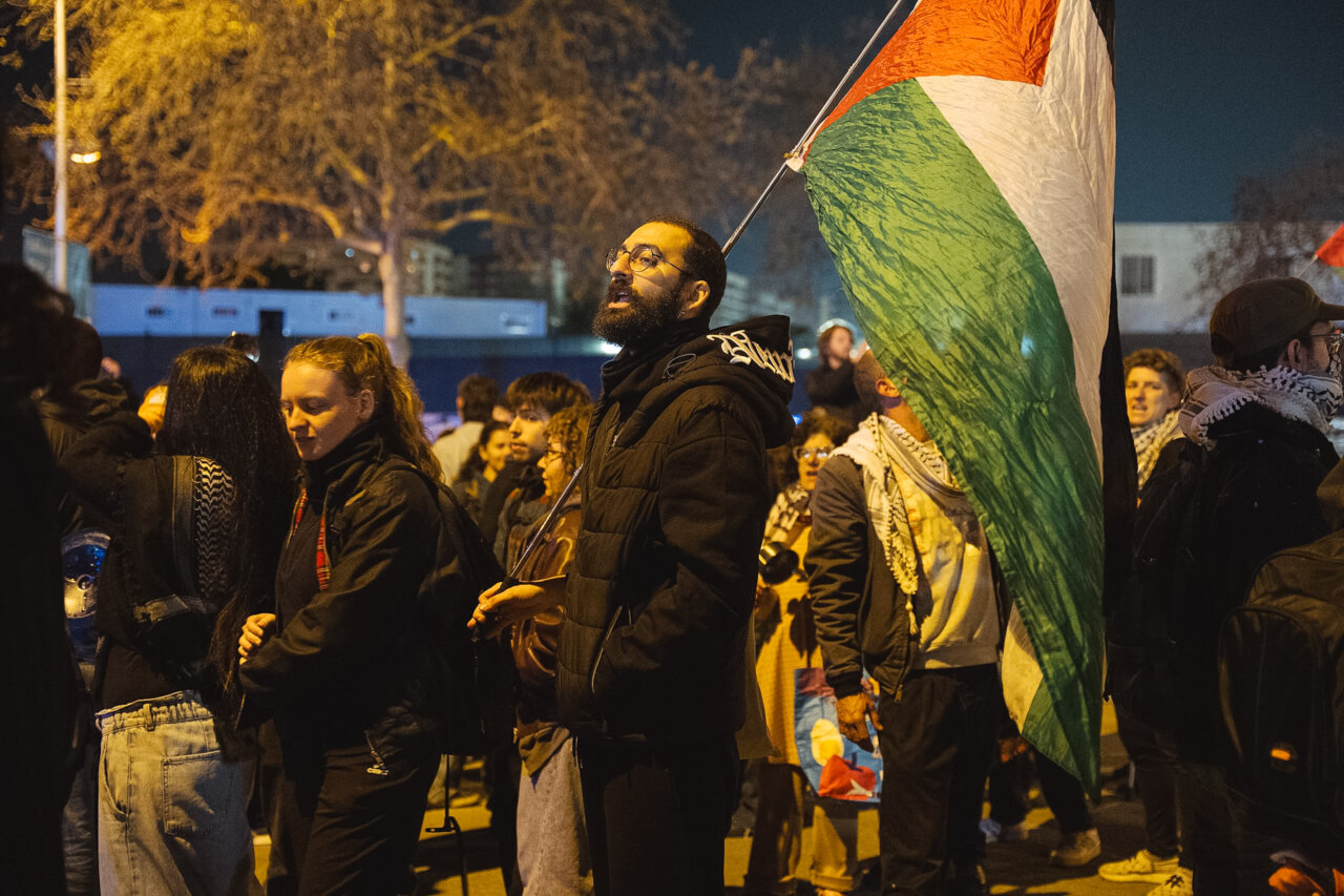 Un manifestante con una bandera de Palestina durante una concentración en Barcelona contra el partido de la Euroliga entre el FC Barcelona y el Hapoel Tel Aviv (Marc Font, ACN)