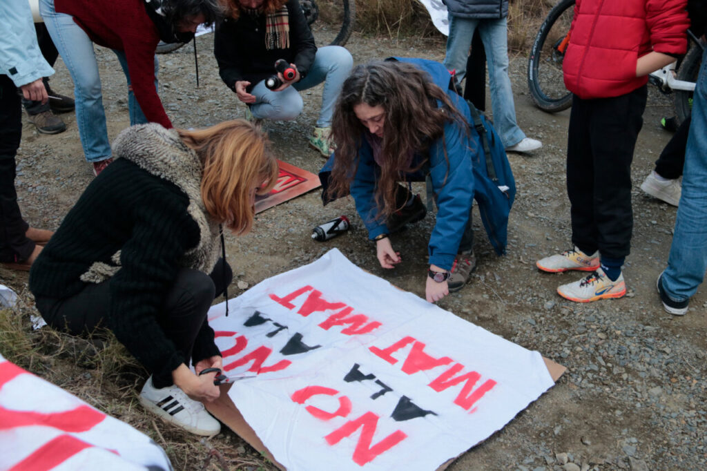 Dues dones elaboren pancartes en contra del projecte de la MAT entre l'Aragó i Catalunya en un acte celebrat a Almoster