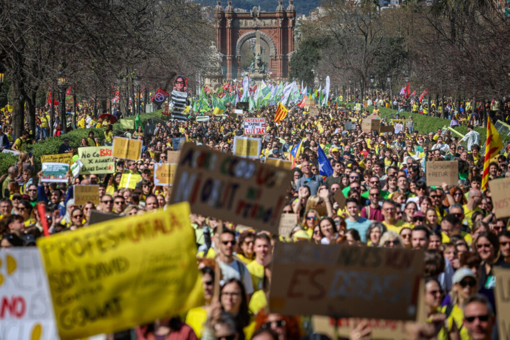 Gran manifestació de docents a Barcelona amb pancartes i banderes