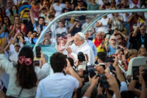 El papa Lleó XIV amb un nadó envoltat de fidels a l'estadi