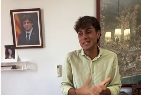 Alcalde de Cabrera parlant amb retrats de Puigdemont i Pujol al fons.