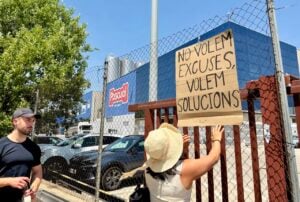 Una treballadora de Pascual a Gurb penja una pancarta. (Laura Busquets - ACN)