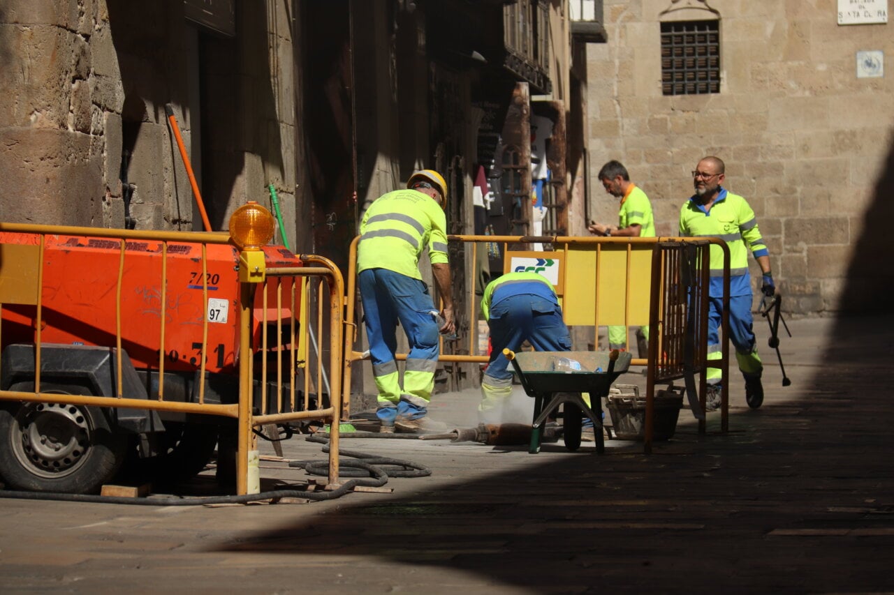 Un grup de treballadors del sector de la construcció arrerglant un desaigüe a la plaça del Rei (Aina Martí, ACN)